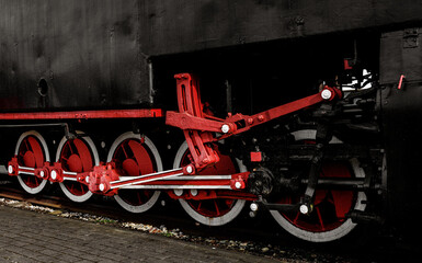 Red metal wheels of a vintage steam locomotive.