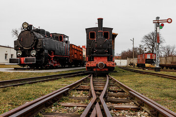 Retro locomotive, steam train parked in an outdoor depot.