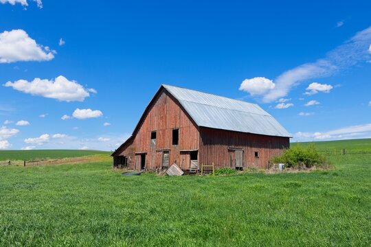 Old red barn under a bright blue sky.