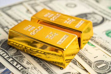 Gold bar on US dollar banknotes money, economy finance exchange trade investment concept.