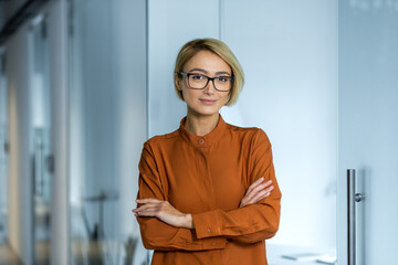 Portrait of a young beautiful woman designer, architect, programmer standing in the office with her...