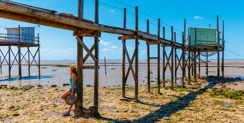 Traveler woman enjoying view of traditional carrelet ( traditional fishing hut)- Charente Maritime- Tour tourism in France - obrazy, fototapety, plakaty