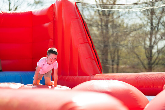 Smiling child on knees and playing in bouncy house