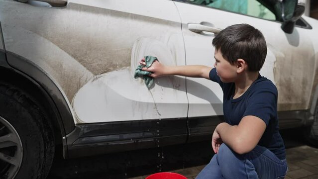 Small Boy Washing Dirty Car