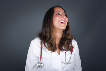 Joyful European woman having fun and laughs at good joke or sings wears casual clothes, standing...