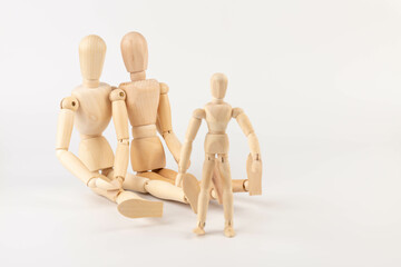 Family of wooden puppets with the kid on white background.