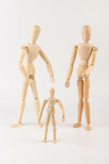 Family of wooden puppets with the kid on white background.