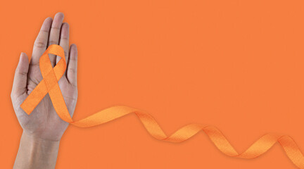 February awareness month. Hand holding Orange Ribbon for Leukemia, Kidney cancer day, world...