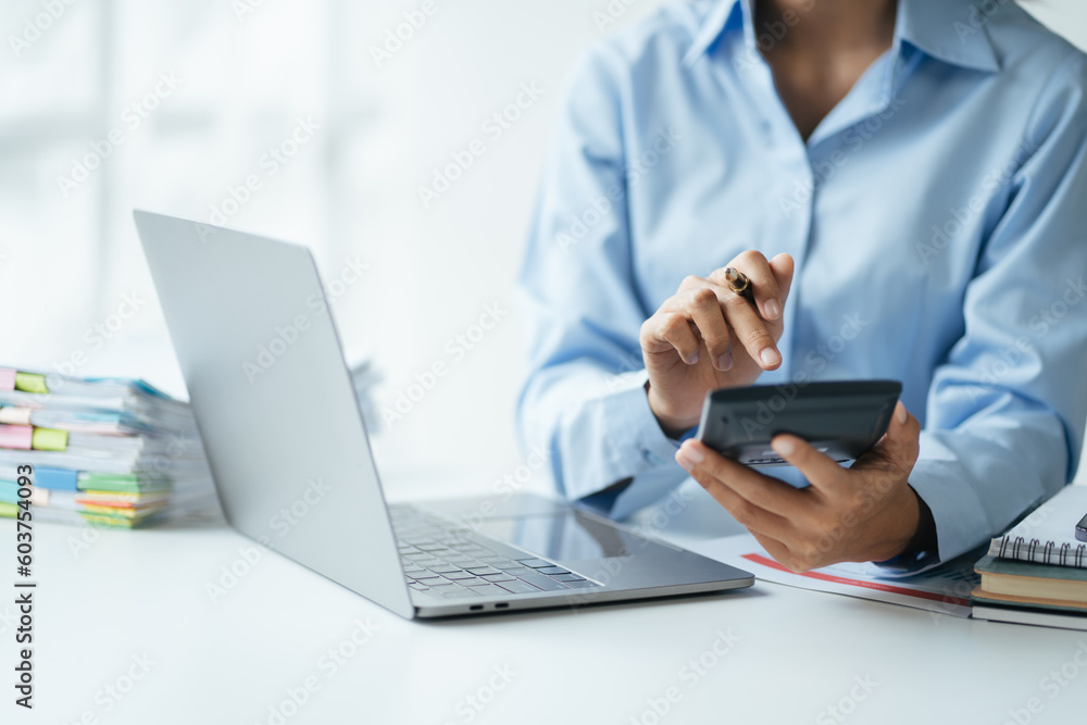 Poster close up view of accountant working with financial investment on calculator at office desk.
