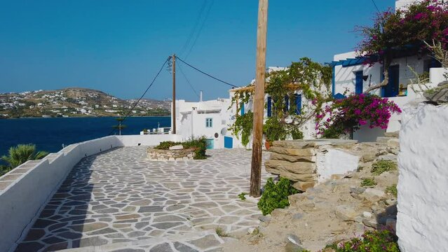 Parikia, Paros Island, Greece- 26 September 2020: Narrow street of the old town. Traditional, withe architecture and a stone path with white joints.