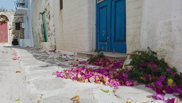 Parikia, Paros Island, Greece- 26 September 2020: Narrow street of the old town. Traditional, withe architecture and a stone path with white joints.