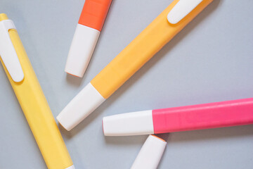 Colorful markers on a grey background. Top view of felt-tip pens.