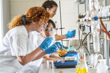 Group of female chemistry scientists doing experiments in the lab.	
