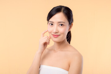 Obraz na płótnie Canvas Beautiful girl asian model touching fresh glowing hydrated facial skin on beige background closeup. Beauty face young woman with natural makeup and healthy skin portrait. Skin care concept