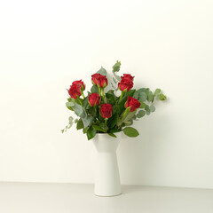Bouquet of red roses on a white wall background