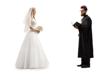 Full length profile shot of a bride standing with a priest holding a bible