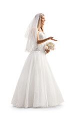 Fototapeta premium Full length profile shot of a bride with a veil holding a bridal bouquet and gesturing with hand