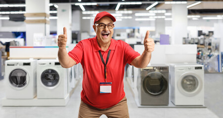 Excited mature salesman gesturing thumbs up in an appliance store