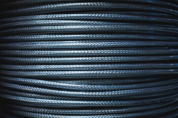 Close-up of a cable coil in a metal winding. A wound cable in a stranded metallized winding in a storage warehouse of a manufacturing enterprise