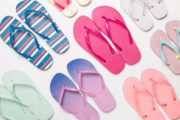 Many bright flip flops on color background, top view