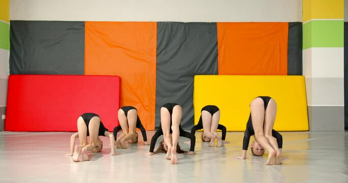 Little girls practice at gymnastics class in a studio