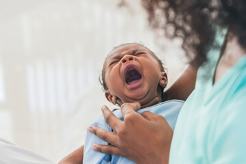 Blurred soft images, half Nigeria half Thai, 1-month-old baby newborn son, crying while his mother being held, to relationship in family and infant newborn concept.