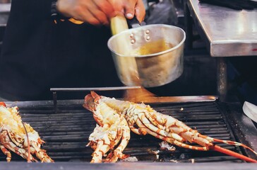 Grilled spiny lobster brushed with sauce as a dinner menu in the night market at Hau Hin, Thailand.