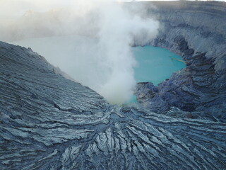 Krater aktywnego wulkanu Ijen wypełniony niebieskim jeziorem kwasu siarkowego na wschodniej Jawie w Indonezji - 603776859