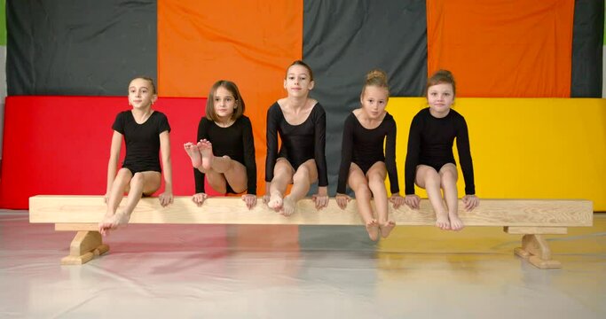 Little girls practice at gymnastics class in a studio