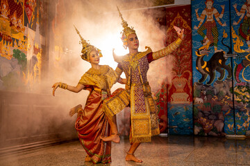 Beautiful Asian woman wear Thai traditional dress action of dancing together with man stand in...