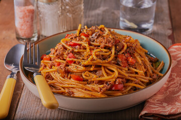 Traditional dish of Spaghetti bolognese garnished with herbs and seasoning.