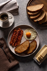 Breakfast with fried Bacon and Eggs, toast, and Coffee