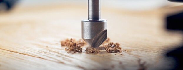 Countersink drill bit with steel triangle ruler make sink in hole for screw in wooden oak plank