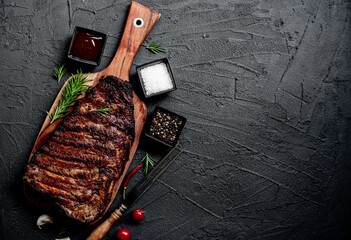 pork ribs on a grill on a stone background with copy space for text
