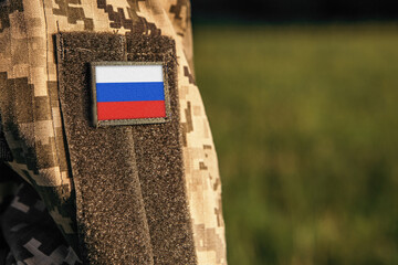 Close up millitary woman or man shoulder arm sleeve with Russia flag patch. Troops army, soldier camouflage uniform. Armed Forces, empty copy space for text

