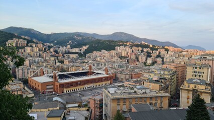 Genoa, Italy - May 6, 2023: Top view of the city of Genoa at sunset from the mountains. Aerial view of Genoa and Sampdoria soccer teams stadium in Genoa Marassi in Italy.