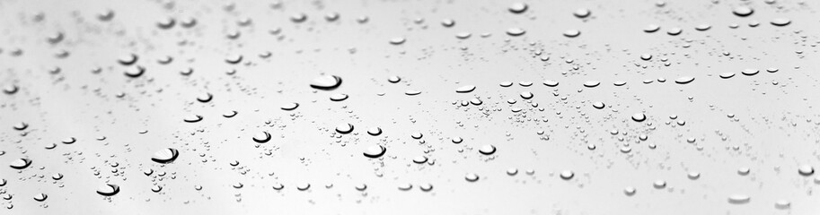 Water drops of rain on glass with bokeh. Selective focus. Banner.