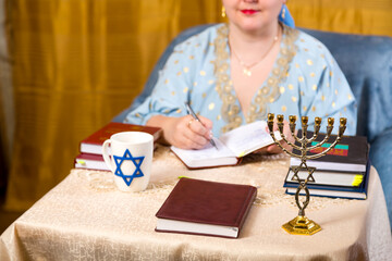 Jewish woman in headdress kisui rosh tradition teacher takes notes for lectures.