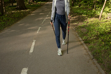 Cropped Female Legs Trekking With Sticks, Step Along The Path In Park, Cropped Hiking Female, Nordic Walking With Sticks, Cross-country Running. Horizontal Plane. Copy Space For Text.