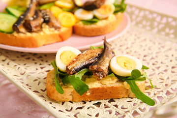 Tasty sandwich with canned smoked sprats on table