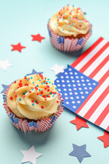 Tasty patriotic cupcakes with flag of USA and stars on blue background. American Independence Day