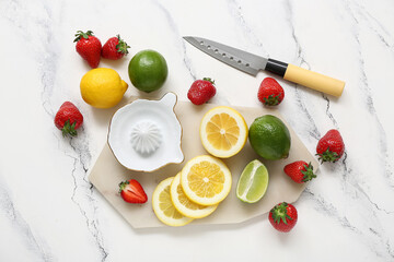 Board of juicer and ingredients for preparing strawberry lemonade on white background