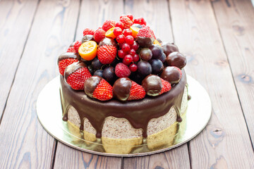 Rich chocolate oreo cake decorated with sauce and fresh berries, strawberry, cherry and blueberry