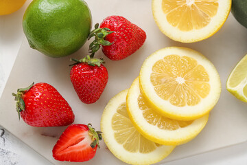 Fototapeta na wymiar Board of fresh strawberries with lemon and lime, closeup