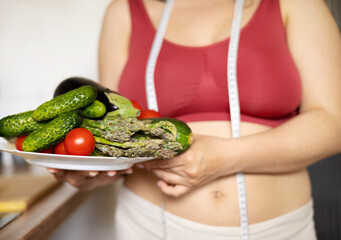 overweight woman in kitchen with measure tape centimeter on waist,holding belly fat with...
