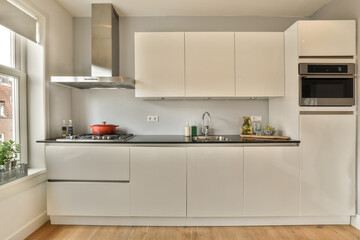 a kitchen with white cabinets and black counter tops on the island in front of the sink is an oven, microwave and dishwasher