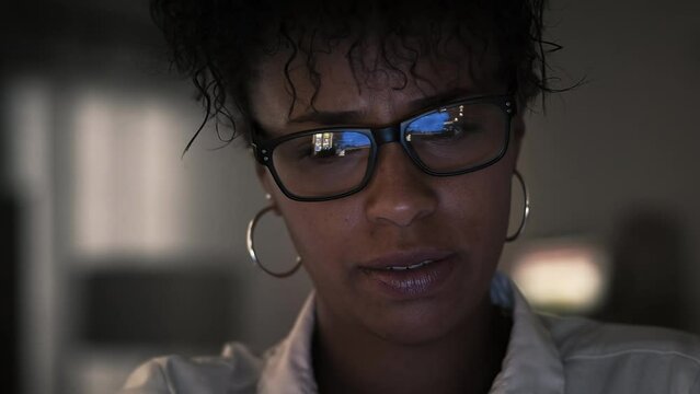 Lateral Dolly of Young African American  Cheerful Businesswoman in Eye Glasses Late at Night Working in Front of Computer. Office Background.