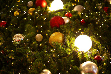 Obraz na płótnie Canvas close up decoration ball and light bulb on christmas tree at night 