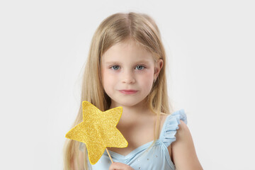 Studio portrait of beautiful little princess holding star shaped magic wand	
