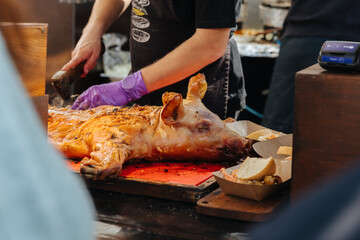 Suckling pig being cut apart by a cook